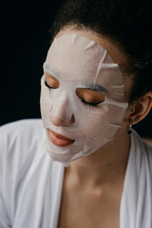 a woman with a sheet mask on her face, trending on pexels, square facial structure, made of lab tissue, japanese, low key