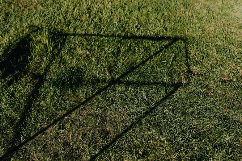 a white frisbee sitting on top of a lush green field, an album cover, by Attila Meszlenyi, land art, casting long shadows, square lines, glass refraction, outdoor photo