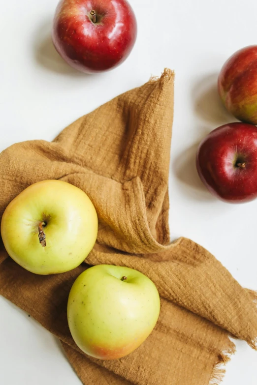 a pile of apples sitting on top of a table, wearing wheat yellow gauze, sustainable materials, towels, snacks