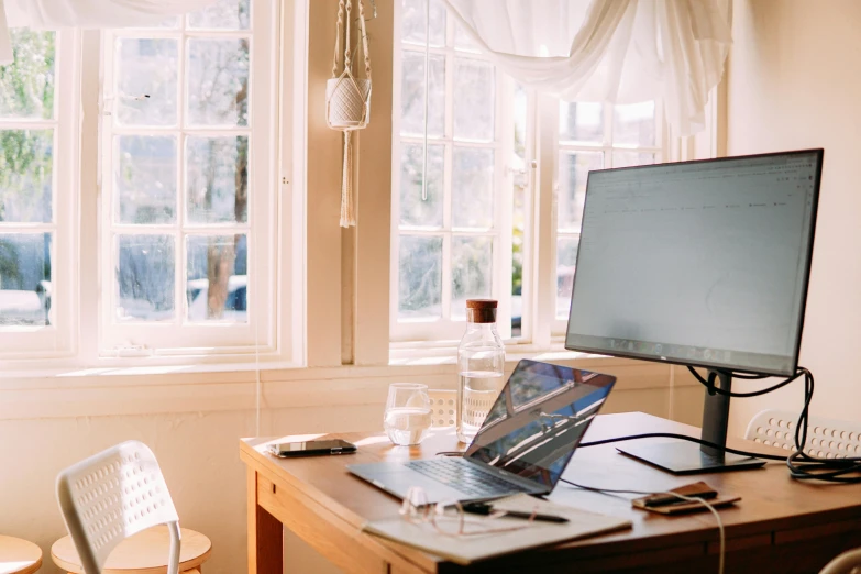 a laptop computer sitting on top of a wooden desk, trending on pexels, sunlit windows, with screens and silks, white background”, sitting across the room