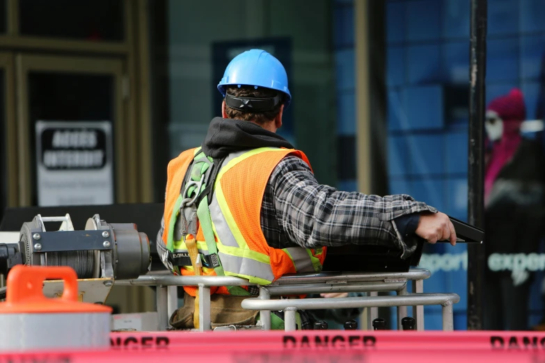 a construction worker wearing a safety vest and a hard hat, pexels contest winner, man sitting facing away, avatar image, candid photo, close-up photo