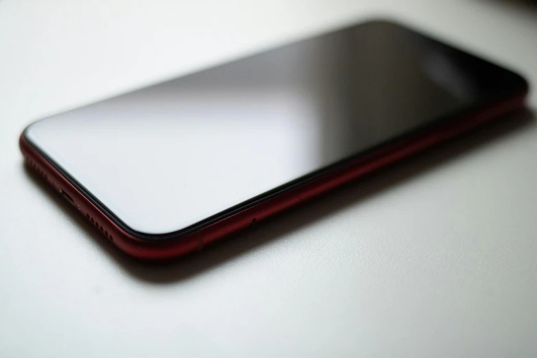 a close up of a cell phone on a table, a picture, by Robbie Trevino, pexels, photorealism, gradient red to black, minimalist photo, rounded corners, portrait n - 9