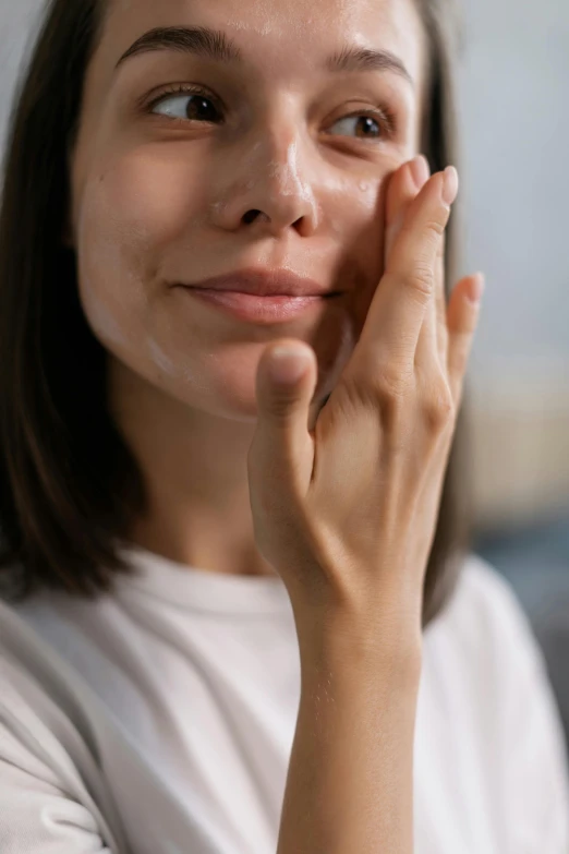 a woman holding her hand to her face, trending on pexels, renaissance, cream dripping on face, silicone skin, petite, rectangle