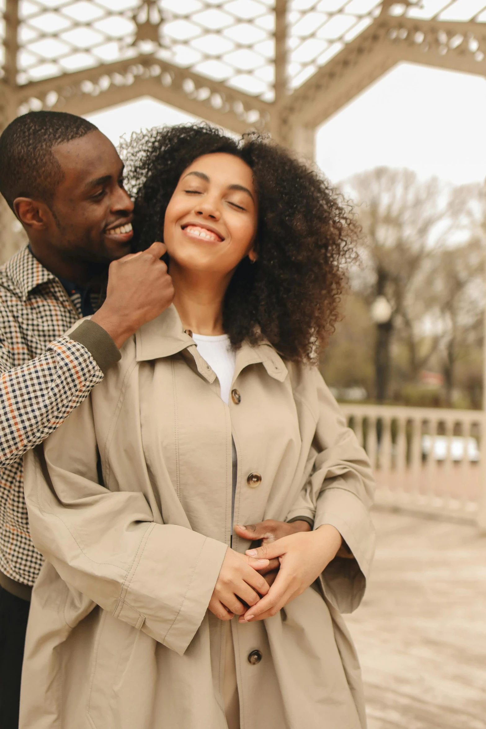 a man standing next to a woman in a trench coat, trending on pexels, renaissance, east african man with curly hair, two men hugging, beautiful lady, hearts