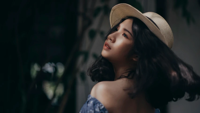 a close up of a woman wearing a hat, pexels contest winner, asian girl, casual pose, over the shoulder, portrait soft low light