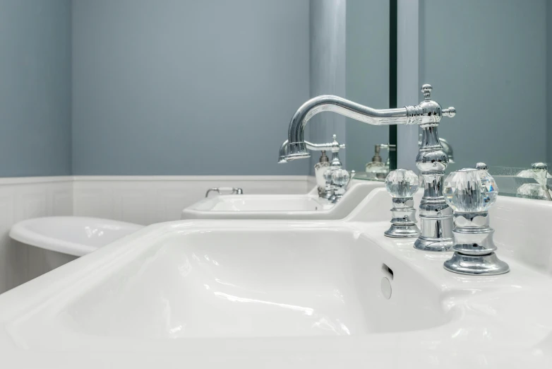 a white sink sitting under a mirror in a bathroom, inspired by Edwin Deakin, gleaming silver, middle close up, grey, picton blue