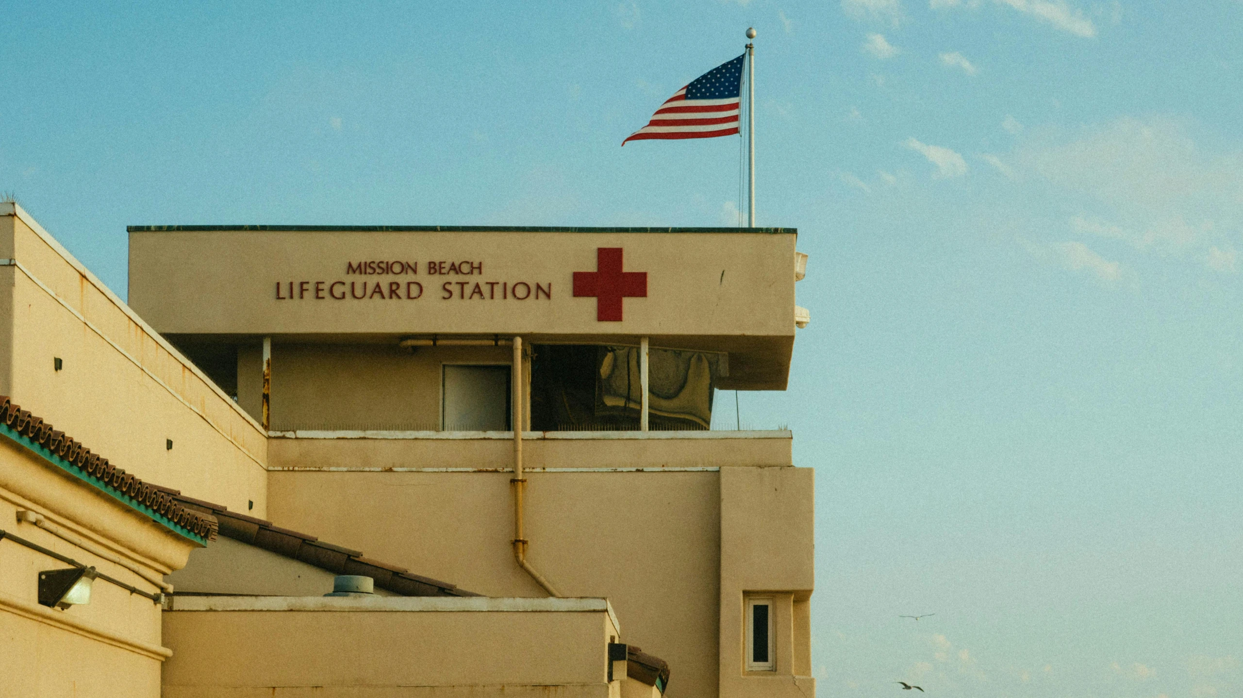 a building with a flag on top of it, unsplash, american realism, first aid kit, long beach background, albion, brown