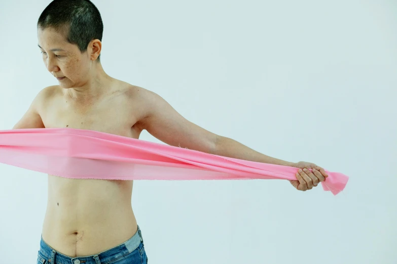 a shirtless man holding a pink piece of cloth, inspired by Ren Hang, unsplash, hyperrealism, chinese ribbon dance, shinichi fukuda, non-binary, bandage on arms