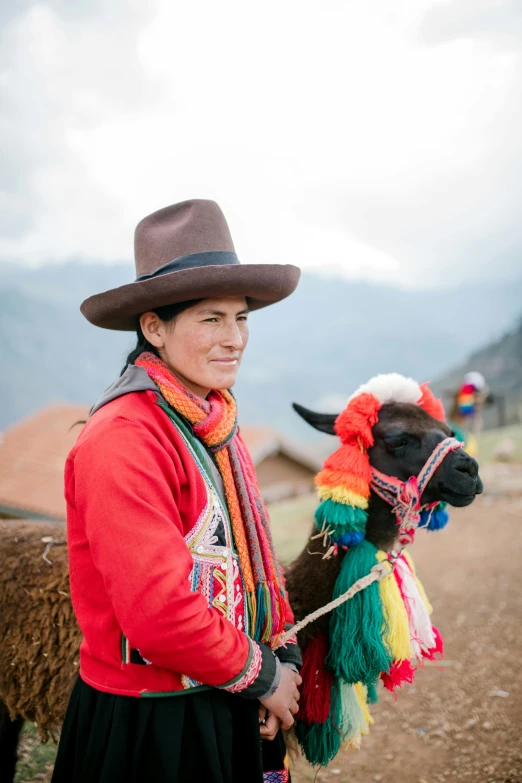 a woman in a hat standing next to a llama, multicoloured, wearing adventuring gear, wearing authentic attire, woman with braided brown hair