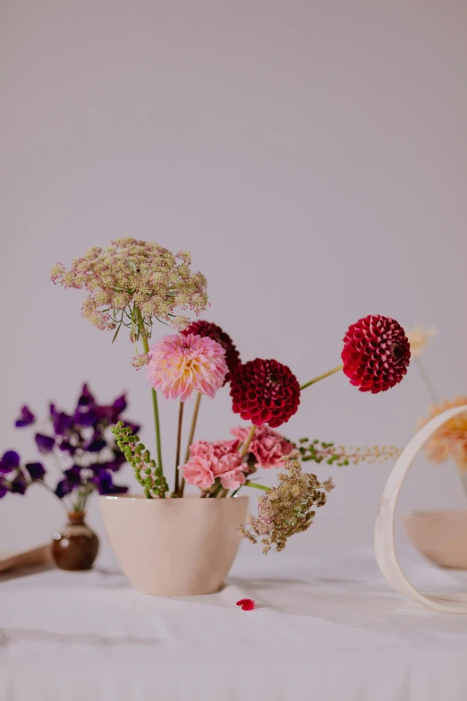 a white table topped with a vase filled with flowers, unsplash, vanitas, coxcomb, natural and organic and flowing, pink arches, full product shot