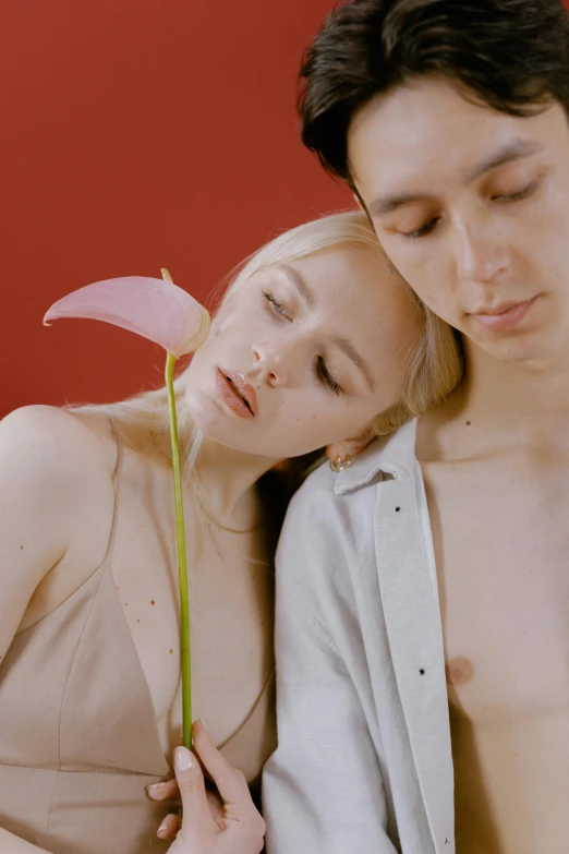 a man standing next to a woman holding a flower, inspired by Ren Hang, trending on pexels, renaissance, pale red, photoshoot for skincare brand, studio shoot, soft skin