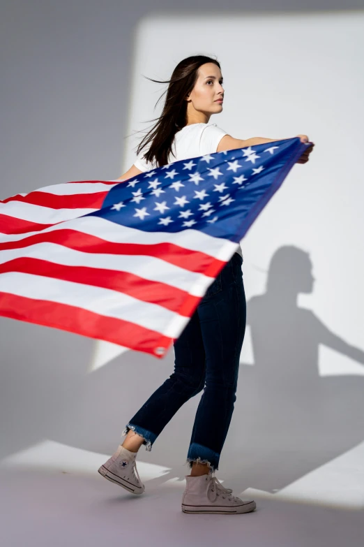 a woman holding an american flag in her hands, a picture, shutterstock contest winner, full body profile camera shot, hero pose, asian women, denim