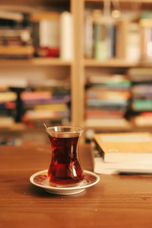 a cup of tea and a book on a table, by irakli nadar, arabesque, small library, brown, premium quality, multicoloured