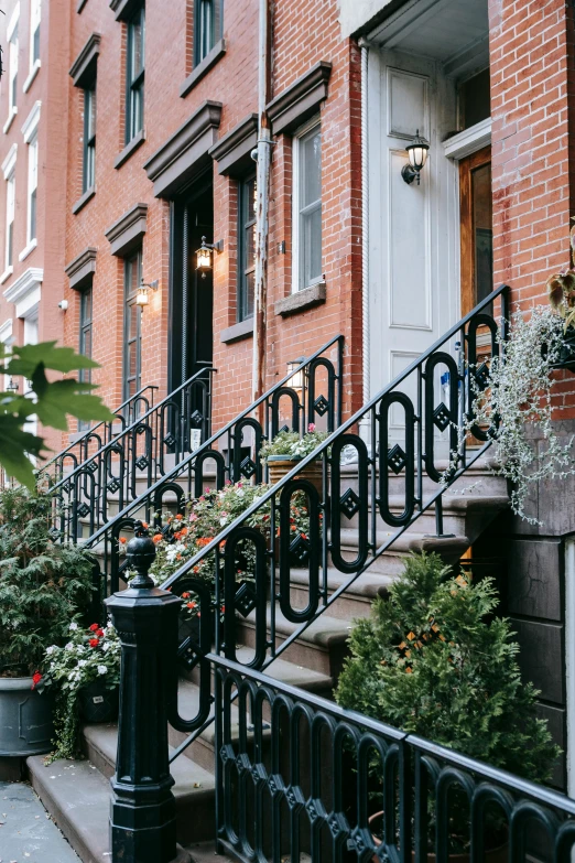 a row of stairs in front of a brick building, lush brooklyn urban landscaping, wrought iron, quaint, houses