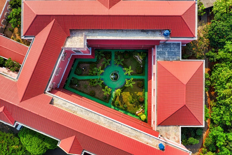 an aerial view of a building surrounded by trees, pexels contest winner, quito school, beautiful isometric garden, red building, rooftop, top down perspecrive