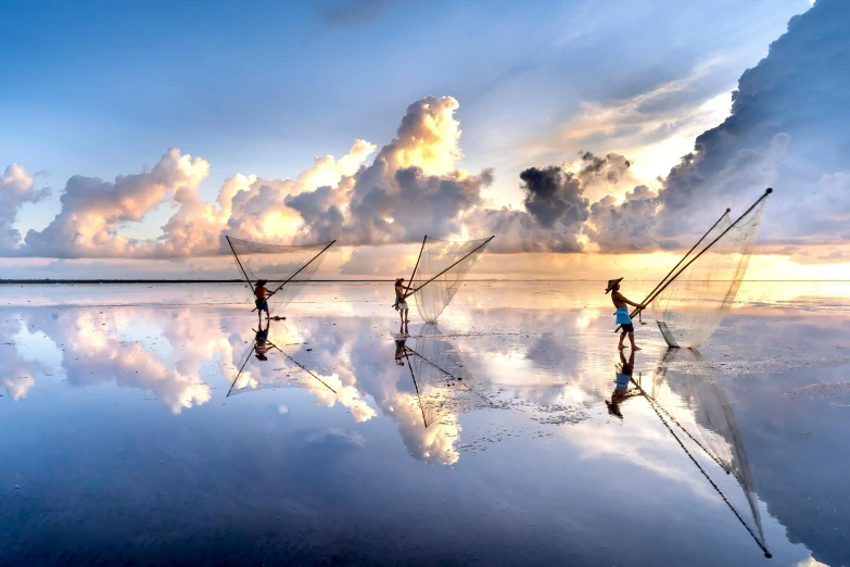 a group of people standing on top of a beach, inspired by Steve McCurry, pexels contest winner, fishing, water reflection, cotton clouds, swings