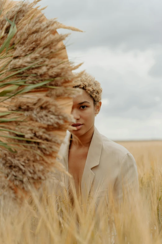 a woman standing in a field of tall grass, by Cosmo Alexander, trending on pexels, renaissance, portrait willow smith, girl in suit, humus, wearing hay coat