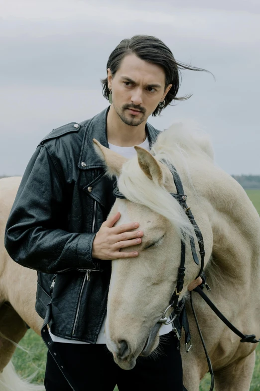 a man standing next to a horse in a field, an album cover, inspired by Adam Dario Keel, trending on pexels, romanticism, leather jacket, avan jogia angel, headshot, style of maciej kuciara