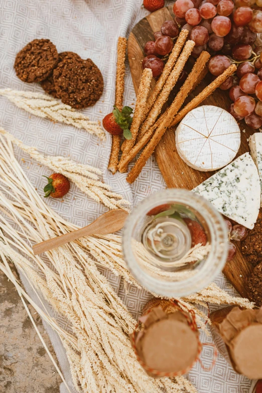 a table topped with lots of different types of food, a still life, dry grass, bubbly, high quality product image”, eating cheese