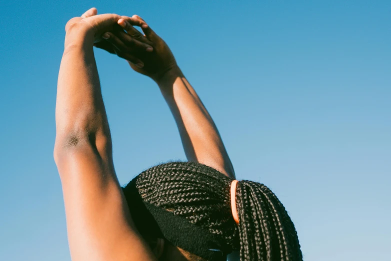 a woman stretching her arms to catch a frisbee, by Matija Jama, trending on pexels, figuration libre, long black braids, clear blue skies, wearing a muscle tee shirt, partially cupping her hands