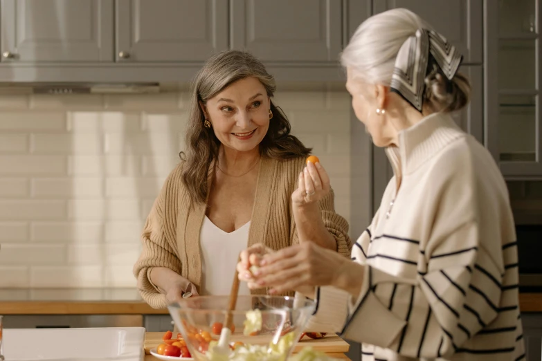 a couple of women standing next to each other in a kitchen, pexels contest winner, renaissance, gray haired, serving suggestion, background image, tv commercial