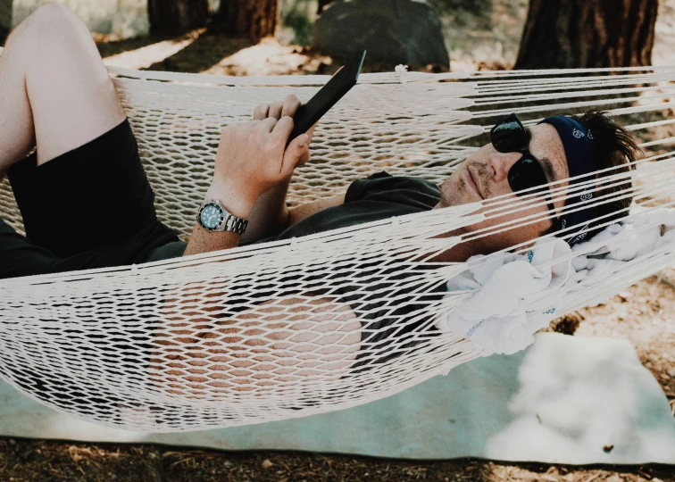 a man laying in a hammock using a cell phone, pexels contest winner, avatar image, macrame, casually dressed, watch photo