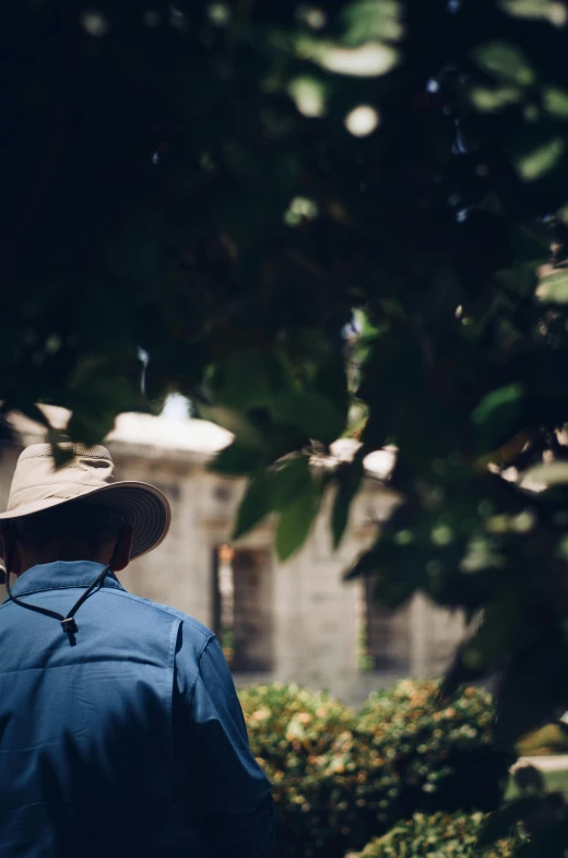 a man in a hat standing under a tree, pexels contest winner, renaissance, mexico city, back portrait of a rugged ranger, in a garden, cinematic shot ar 9:16 -n 6 -g