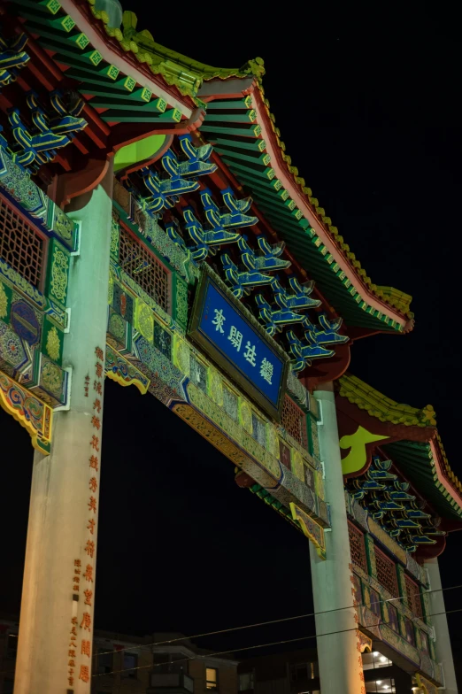 a clock that is on the side of a building, inspired by Hu Zao, cloisonnism, photo taken at night, an archway, colorful signs, detail shot