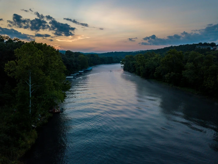 a large body of water surrounded by trees, by Andrew Domachowski, pexels contest winner, summer evening, great river, drone footage, slide show