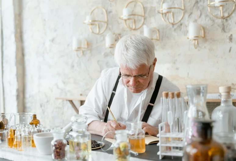 a man sitting at a bar writing on a piece of paper, a photorealistic painting, inspired by Constantin Hansen, pexels contest winner, a silver haired mad, botanicals, molecular gastronomy, gilding