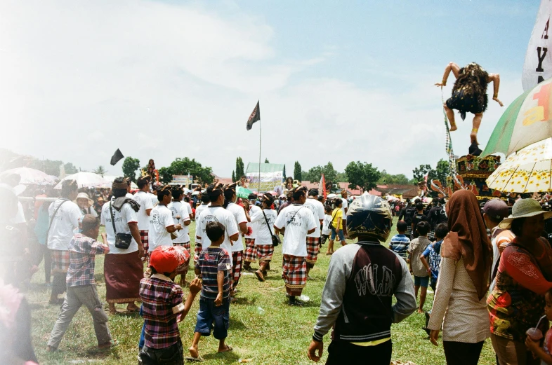 a crowd of people standing on top of a lush green field, by Kogan Gengei, pexels contest winner, happening, tribal dance, banner, south jakarta, tournament