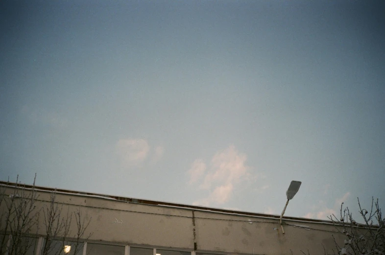 a man flying through the air while riding a snowboard, a polaroid photo, inspired by Elsa Bleda, postminimalism, transmitters on roof, streetlamp, ignant, large sky