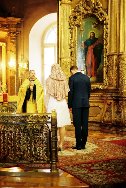 a couple of people that are standing in a room, holy ceremony, palatial scene, head down, yellow carpeted