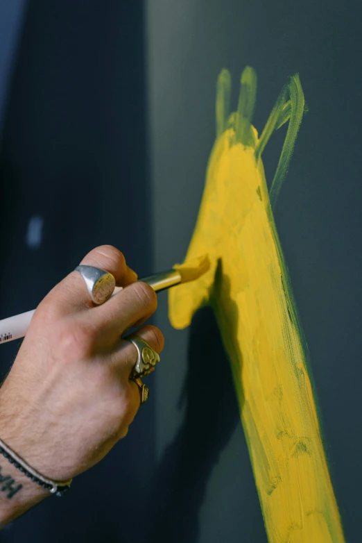 a close up of a person painting on a wall, inspired by Michaelangelo, arbeitsrat für kunst, yellow charcoal, handcrafted, colors: yellow, studio shot