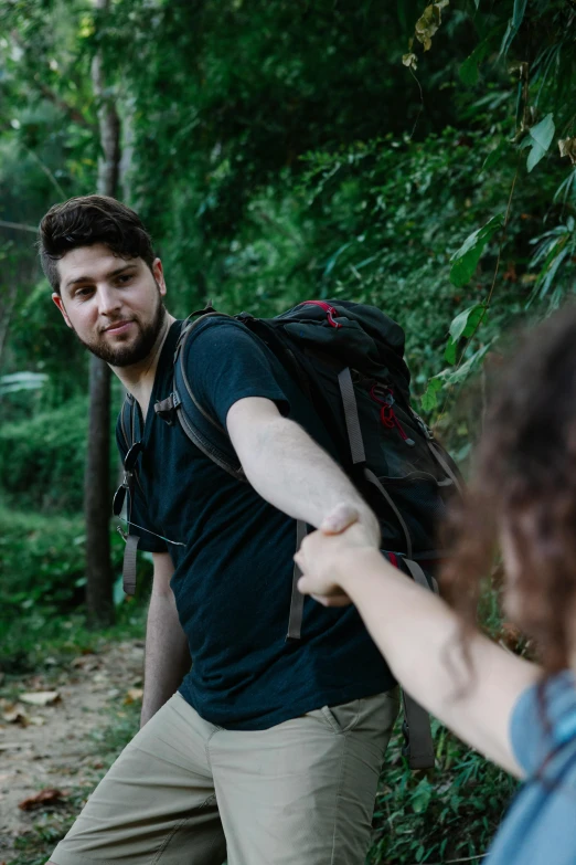 a man and a woman holding hands on a trail, forcing him to flee, with a backpack, zachary corzine, getting ready to fight