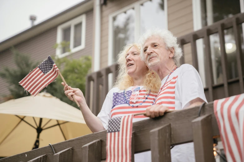 a man and a woman holding an american flag, a portrait, pexels, grandma, avatar image, people watching, high resolution photo