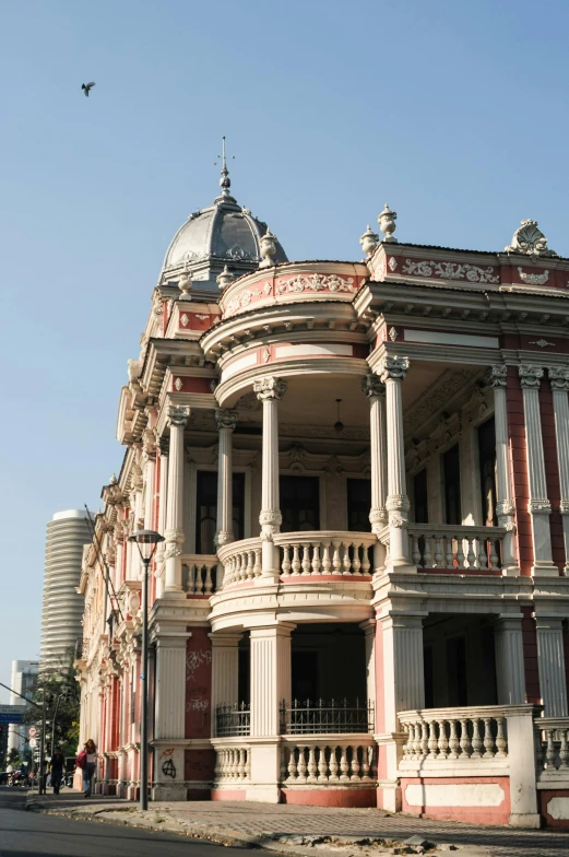 a large building sitting on the side of a road, inspired by Carlos Francisco Chang Marín, art nouveau, bangkok townsquare, ruins, victorian house, colonnade