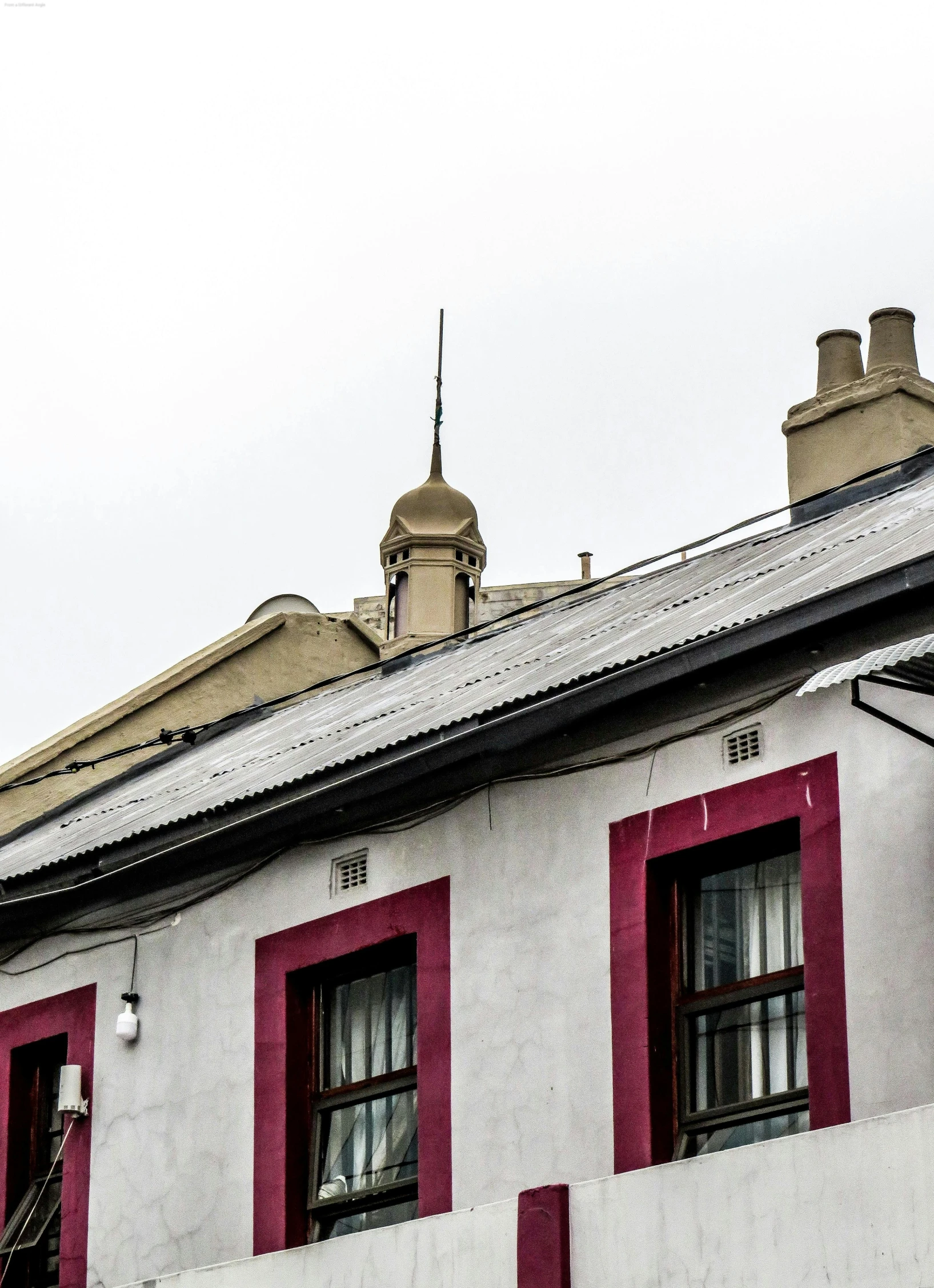 a clock that is on the side of a building, an album cover, by Lee Loughridge, trending on unsplash, art nouveau, simple gable roofs, north melbourne street, cables and wires, palace on top of the hill