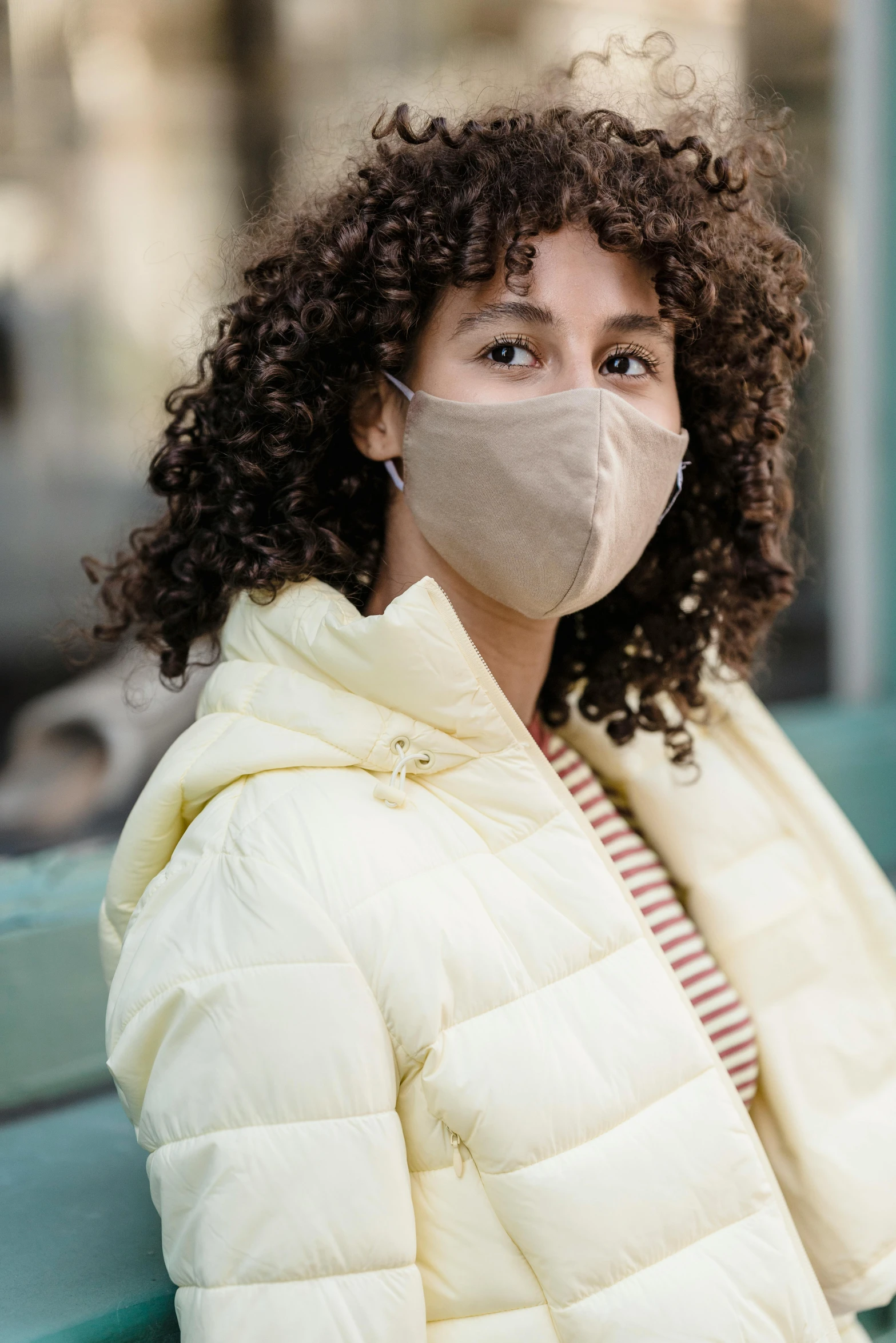 a woman sitting on a bench wearing a face mask, beige mist, 4l, san francisco, promotional image