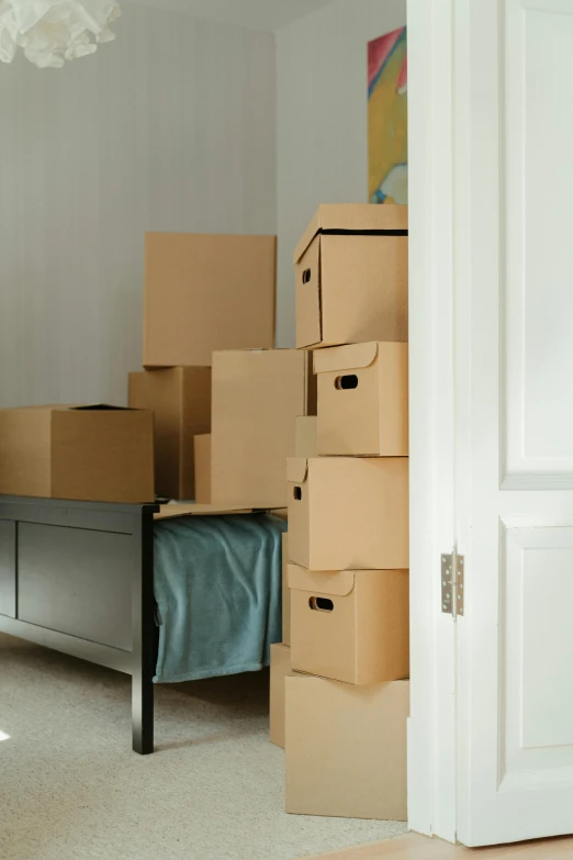 a room with boxes stacked on top of each other, bay area, bed on the right, selling insurance, ignant