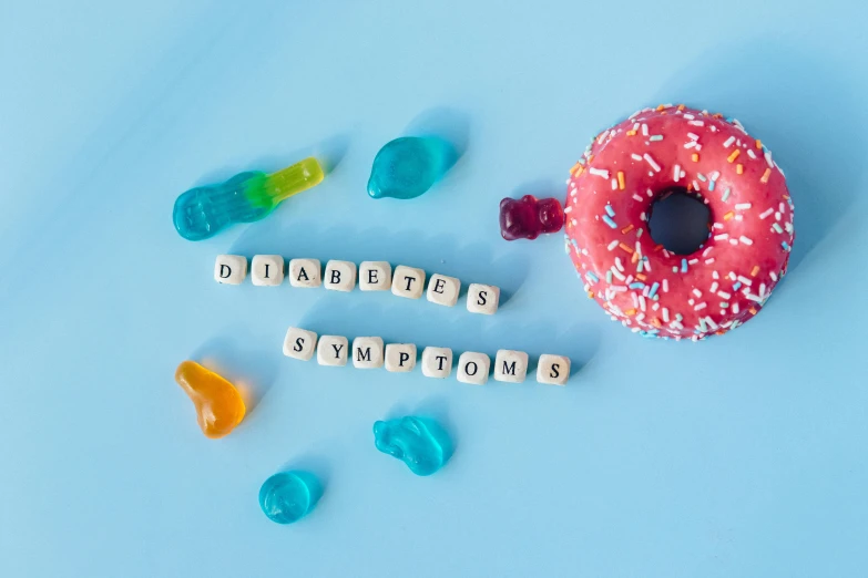 a donut sitting on top of a blue surface, by Rachel Reckitt, pexels, graffiti, gummy bears, medical image, cubes on table, 😭🤮 💔