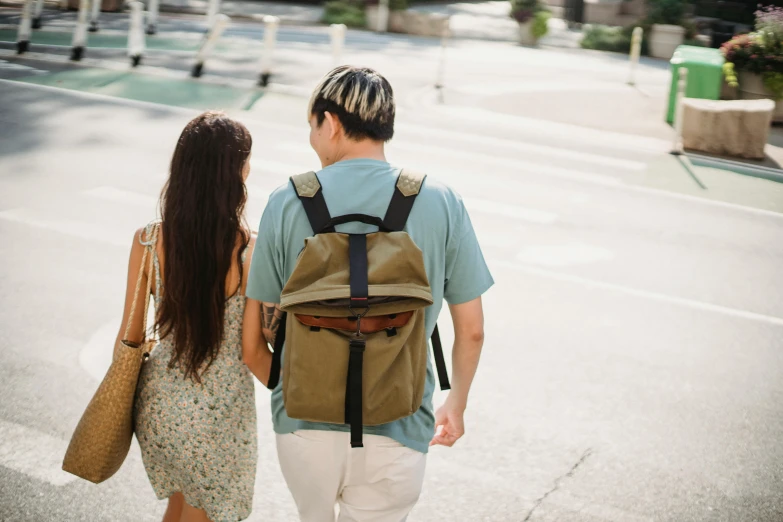 a man and a woman walking down a street, pexels contest winner, square backpack, teenage girl, brown, back turned