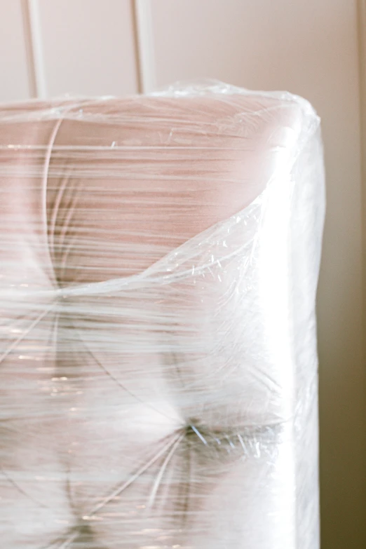 a close up of a piece of furniture wrapped in plastic, unsplash, promo image, moving, cushions, back - shot