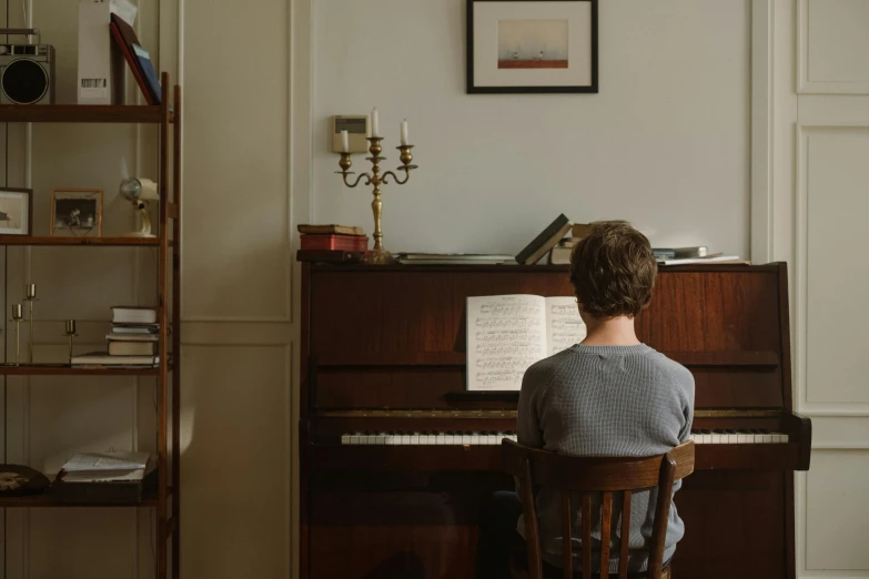 a person sitting at a piano in a room, ignant, studying, high - res, lachlan bailey