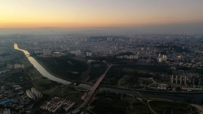an aerial view of a city with a river running through it, by Attila Meszlenyi, pexels contest winner, happening, sao paulo, sun down, pyongyang, panorama view of the sky