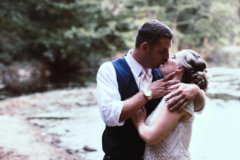 a bride and groom kissing in front of a river, by Ben Thompson, unsplash, sydney hanson, restored, video footage, rustic