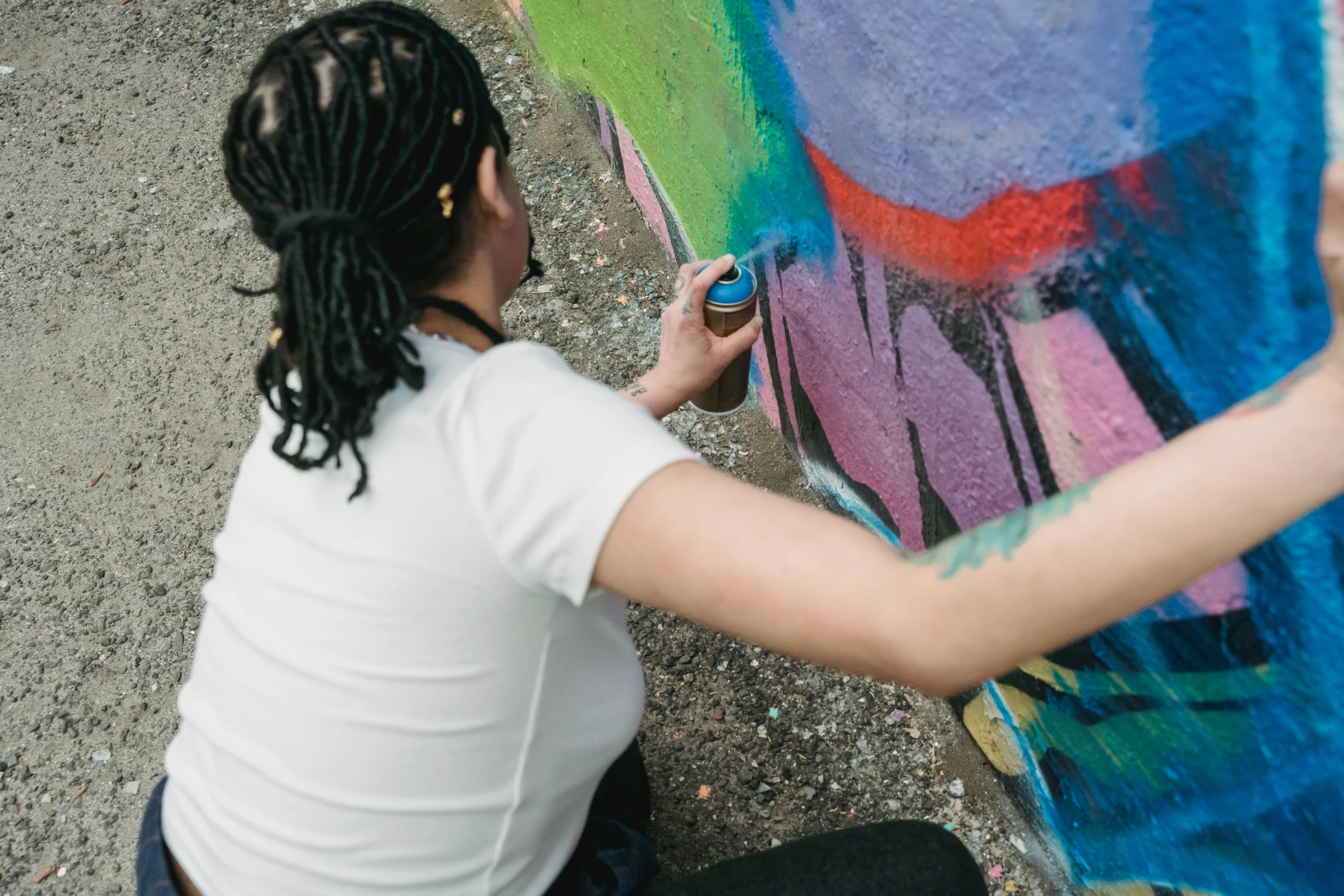 a woman is painting graffiti on a wall, by artist, pexels contest winner, molotow premium color palette, 🎨🖌️, painting on a badge, lesbian art