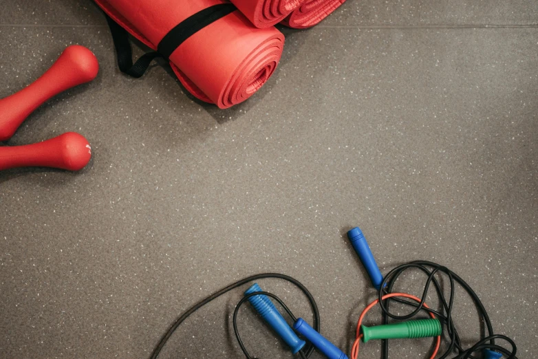 the gym equipment is laid out on the floor, by Carey Morris, trending on pexels, hurufiyya, red and grey only, cords, thumbnail, background image