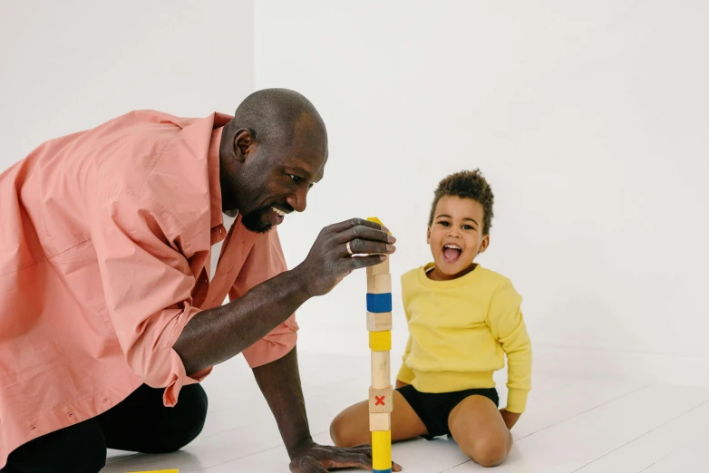 a man playing with a child on the floor, virgil abloh, profile image, building blocks, family friendly