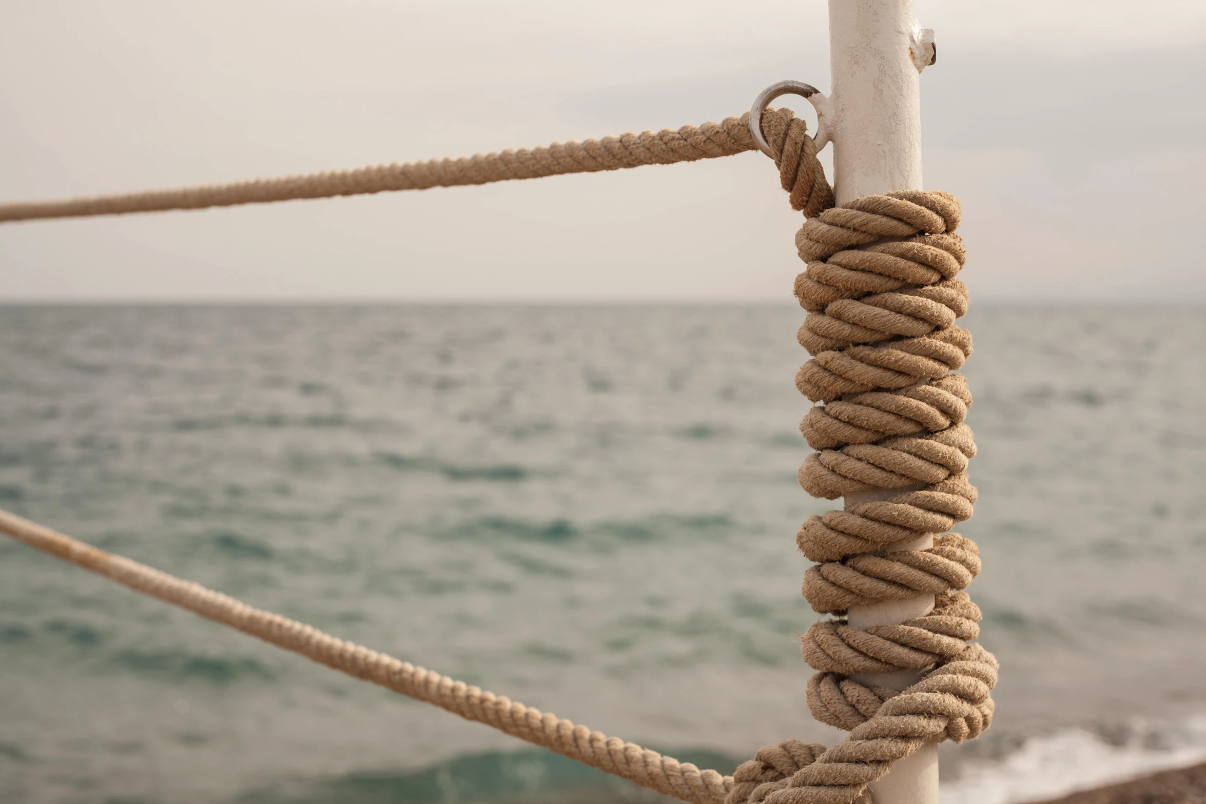 a close up of a rope on a pole near the ocean, overlooking the ocean, agrigento, set sail, ignant